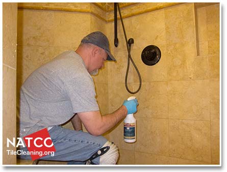 applying soap scum remover to limestone shower